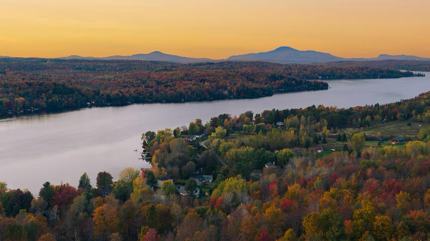 Vue panoramique du lac Lovering à Magog en Estrie au coucher du soleil Vue aérienne du lac Lovering à Magog en Estrie avec les montagnes et les couleurs d’automne