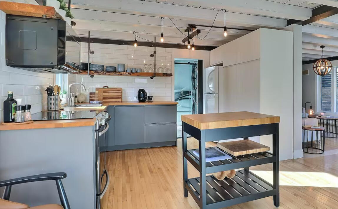 Cuisine tout équipée du chalet Le Monarque près de Magog en Estrie avec îlot central et design moderne Cuisine moderne du Chalet Le Monarque près de Magog avec îlot central et plancher de bois